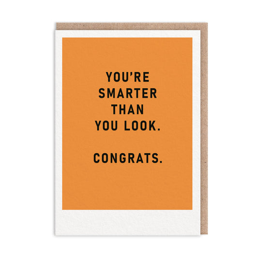 Congratulations card with an orange background and black text that reads "You're Smarter Than You Look. Congrats"