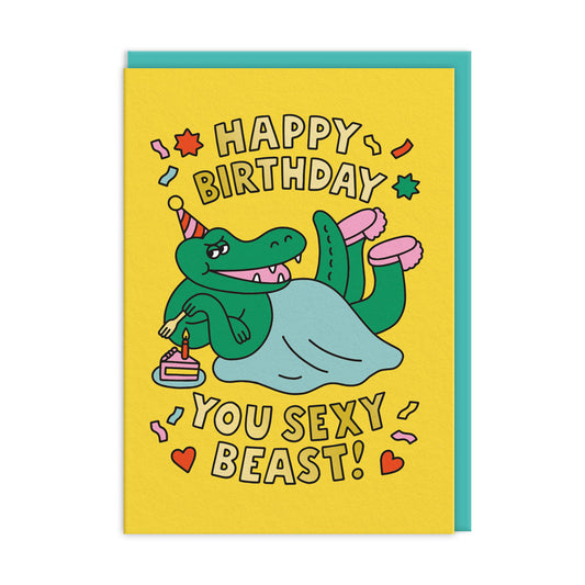 Yellow birthday card with a crocodile illustration. Gold Foil text reads "Happy Birthday You Sexy Beast"